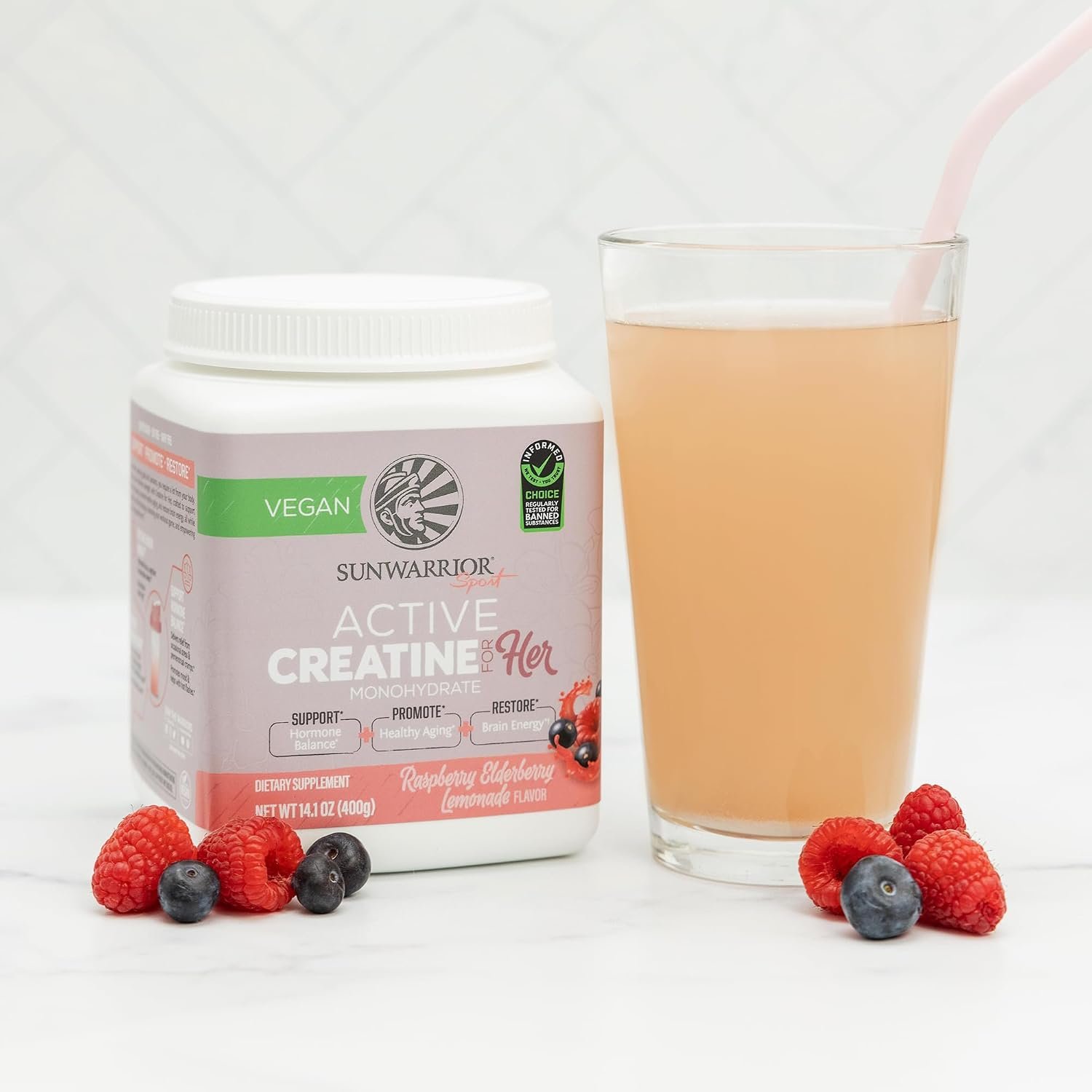 Macro close-up of raspberry lemonade creatine powder in a clear scoop, showing fine crystalline texture
