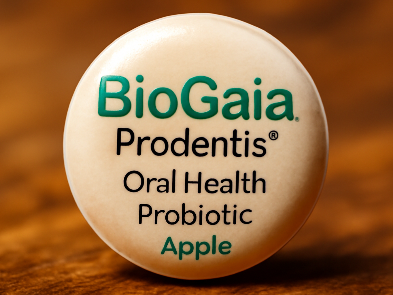 Close-up of a single BioGaia Prodentis apple probiotic tablet with glossy finish and shallow depth of field